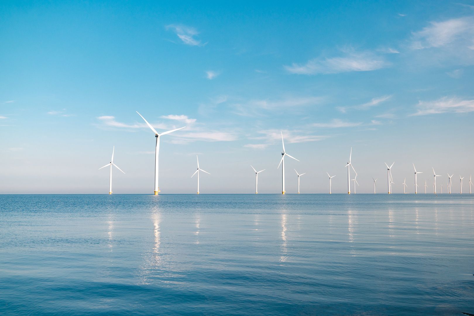 Eine Gruppe von Windkraftanlagen steht im Ozean, um erneuerbare Energie zu erzeugen.